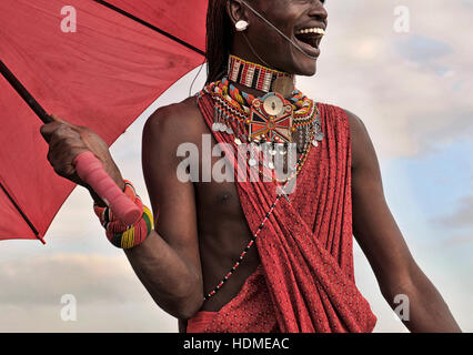 Un guerriero Masai sorrisi felicemente indossando il tradizionale perline gioielli tribali. Kenya, Africa. Foto Stock