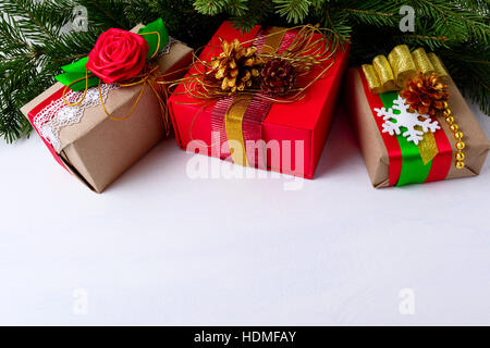 Sfondo di Natale decorato con confezioni regalo di Natale e rami di alberi. Sfondo di natale con rami di abete e carta kraft presenta di incarto. Foto Stock