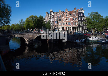 Crooked edifici nelle prime ore del mattino sole estivo su un angolo della Browersgracht e Prinsengracht, Amsterdam, Paesi Bassi Foto Stock