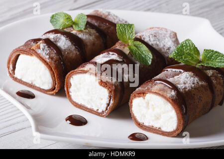 Frittelle al cioccolato con crema di formaggio su una piastra di close-up orizzontale Foto Stock