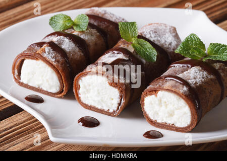 Crepes al cioccolato con crema di formaggio su una piastra di close-up orizzontale Foto Stock