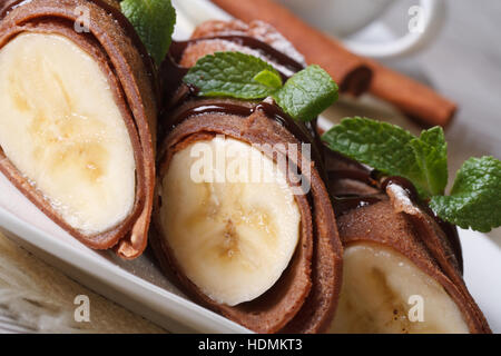 Frittelle di cioccolato con banane su una piastra bianca macro. orizzontale Foto Stock