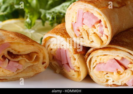 Frittelle farcite con prosciutto e formaggio su una piastra bianca. horizontal macro Foto Stock