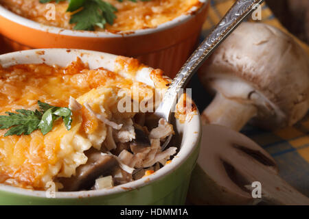 Al gratin con pollo e funghi in un cucchiaio, horizontal macro. Stile rustico Foto Stock