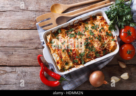 Enchilada messicano in una teglia con gli ingredienti sul tavolo. vista orizzontale dal di sopra Foto Stock