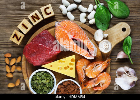 Gli alimenti ricchi di zinco come salmone, gamberetti, carne, formaggio giallo, spinaci, funghi, cacao, semi di zucca, aglio, fagiolo e mandorle. Vista superiore Foto Stock