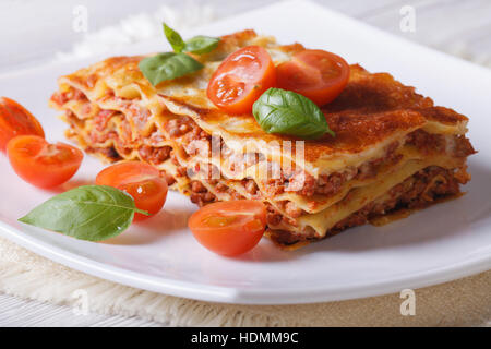 Le lasagne italiane con basilico fresco su una piastra bianca orizzontale. Foto Stock