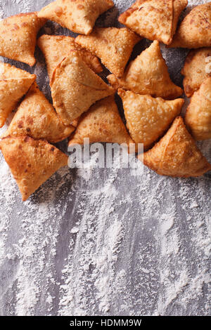 Un mucchio di cottura samosas su un tavolo infarinato. verticale in alto Visualizza ingrandimento Foto Stock
