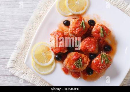 Filetto di pesce in salsa di pomodoro con olive sulla piastra. vista orizzontale dal di sopra Foto Stock