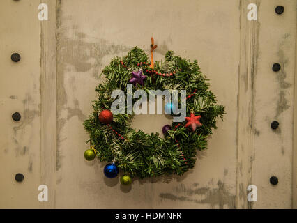 Ghirlanda di Natale sulla porta di legno per esterno closeup. verde tradizionale ghirlanda di Natale sulla porta di legno. Felice anno nuovo Foto Stock