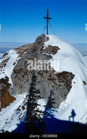 Ombra di un uomo nella neve sotto la croce di vetta del Steinerner Jaeger montagna, Reichraming, Austria superiore, Europa Foto Stock