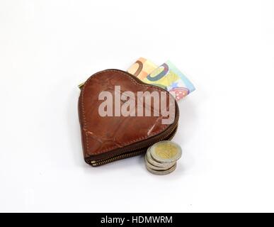 A forma di cuore portafoglio con banconote e monete Foto Stock