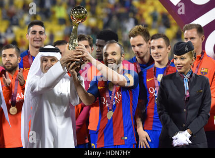 Doha in Qatar. Xiii Dec, 2016. Barcellona è Andres Iniesta (C) e amministratore delegato di Qatar Airways Akbar Al Baker (FRONT L) tenere il trofeo dei campioni dopo un cordiale incontro di calcio tra Barcellona e Al-Ahli Arabia a Doha, capitale del Qatar, Dic 13, 2016. Barcellona ha vinto 5-3. Credito: Nikku/Xinhua/Alamy Live News Foto Stock