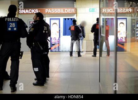 Gli ufficiali di polizia cerca un sospetto in la stazione centrale di Francoforte, Frankfurt am Main, Germania, 13 dicembre 2016. La polizia ha intensificato le pattuglie della stazione al fine di prevenire la criminalità e il traffico di droga. - Attenzione i redattori: il volto del sospetto è stato disturbato al fine di preservare il suo anonimato - foto: Boris Roessler/dpa Foto Stock