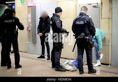 Gli ufficiali di polizia cerca un sospetto in la stazione centrale di Francoforte, Frankfurt am Main, Germania, 13 dicembre 2016. La polizia ha intensificato le pattuglie della stazione al fine di prevenire la criminalità e il traffico di droga. - Attenzione i redattori: il volto del sospetto è stato disturbato al fine di preservare il suo anonimato - foto: Boris Roessler/dpa Foto Stock