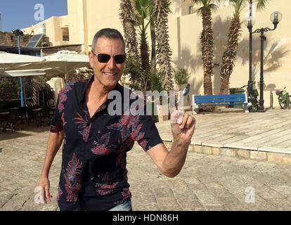 Tel Aviv, Israele. 23 Nov, 2016. Illusionista Uri Geller raffigurata con un cucchiaio ha piegato, vicino alla sua casa nella città vecchia di Tel Aviv, Israele, 23 novembre 2016. Foto: Sara Lemel/dpa/Alamy Live News Foto Stock