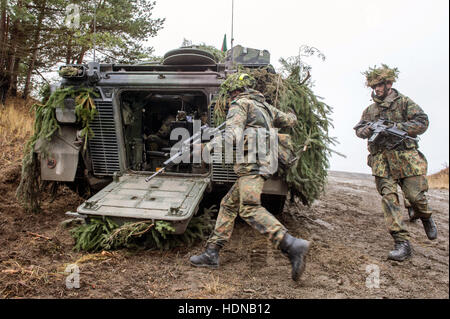 Grafenwoehr, Germania. Xiv Dic, 2016. I soldati dell'esercito tedesco nella corsa verso il portellone posteriore di un blindato di trasporto di personale presso i motivi di perforazione in Grafenwoehr, Germania, 14 dicembre 2016. Il Panzergrenadierbataillon 122 ('Motorized fanteria') da Oberviechtach si stanno preparando per un'assegnazione in Lituania. Foto: Armin Weigel/dpa/Alamy Live News Foto Stock