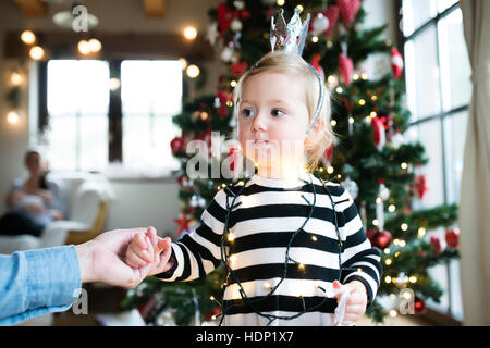 Padre con daugter impigliato nella catena di luce ad albero di Natale. Foto Stock