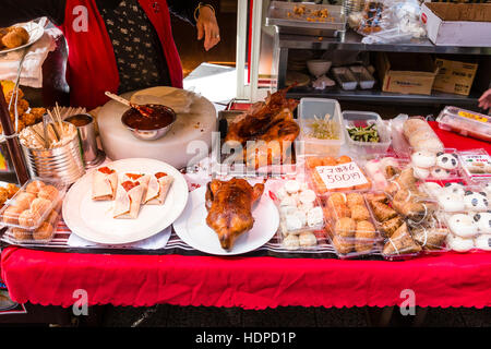 Giappone, Kobe Nankinmachi, Chinatown. Contatore dei cinesi di stallo da asporto, con involtini di pollo e altri alimenti sul display. Molti in contenitori di plastica. Foto Stock