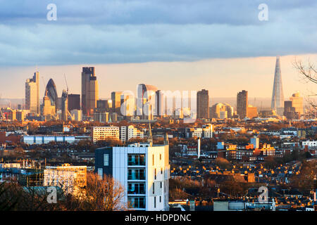 Luce del sole dorato che rientrano su blocchi a torre nella città di Londra al tramonto, visto da Hornsey Lane Bridge, London, Regno Unito Foto Stock