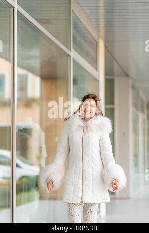 Felice donna in menopausa con rughe camminando in un centro commerciale Foto Stock