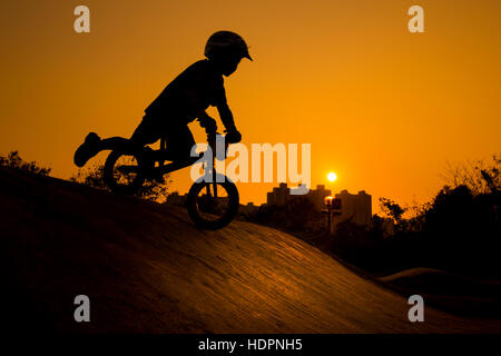 Silhouette di Stunt bambino Bmx Rider - tono di colore sintonizzata Foto Stock