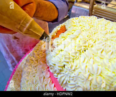 Real pastry chef lavorano nella decorazione di crema su una torta per un matrimonio Foto Stock