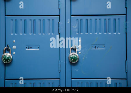 Righe di metallo blu gli armadietti di scuola con serrature Foto Stock