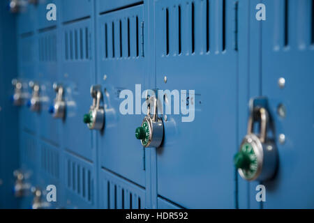 Righe di metallo blu gli armadietti di scuola con serrature Foto Stock