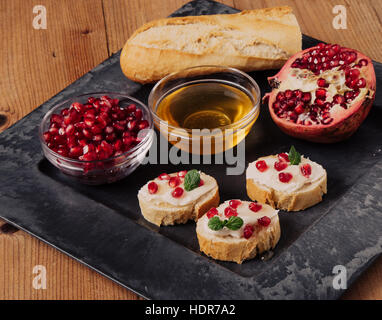 Pane con formaggio cremoso i semi di melograno e miele Foto Stock