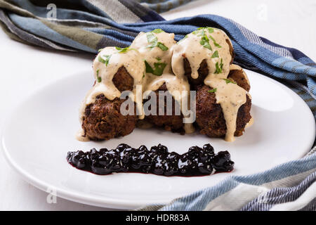 Polpette svedesi con confettura di mirtilli sulla piastra bianca Foto Stock