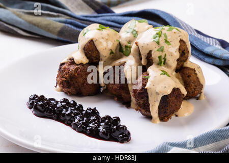 Polpette svedesi con confettura di mirtilli sulla piastra bianca Foto Stock