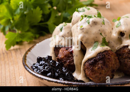 Polpette svedesi con confettura di mirtilli sul tavolo rustico Foto Stock