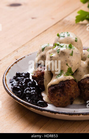 Polpette svedesi con confettura di mirtilli sul tavolo rustico Foto Stock