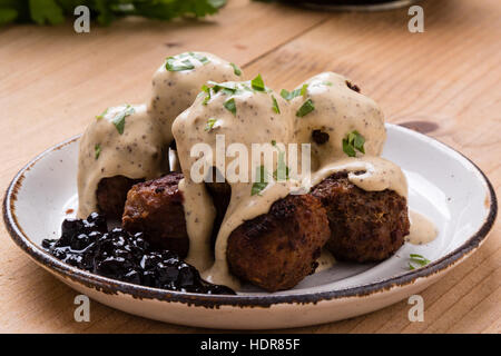 Polpette svedesi con confettura di mirtilli sul tavolo rustico Foto Stock