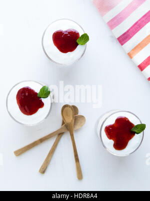 Sana parfait di yogurt con marmellata in vetro sul tavolo bianco Foto Stock