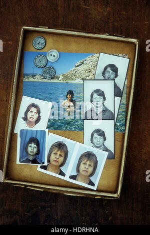Scatola contenente un passaporto in corso di validità e le foto delle vacanze della stessa donna da giovane femminilità di mezza età Foto Stock