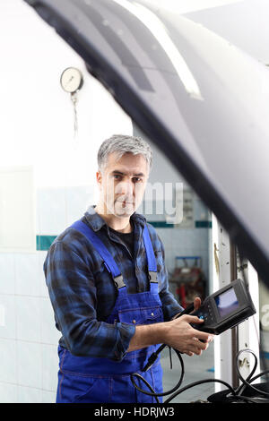 Stazione di diagnostica, meccanico collegato computer diagnostico. Ispezione tecnica del veicolo. La diagnostica del motore. Foto Stock