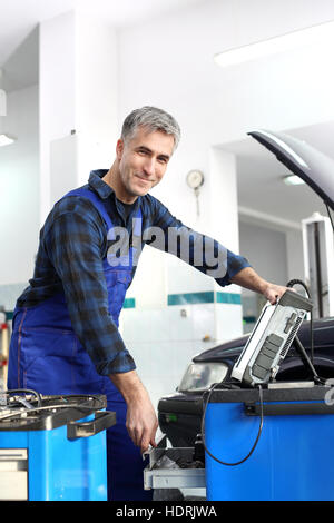 Stazione di diagnostica, meccanico collegato computer diagnostico. Ispezione tecnica del veicolo. La diagnostica del motore. Foto Stock