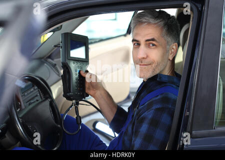 Stazione di diagnostica, meccanico collegato computer diagnostico. Ispezione tecnica del veicolo. La diagnostica del motore. Foto Stock