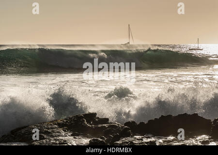 Surf sulla Costa di Kona con barche a vela all'orizzonte; Kona, isola di Hawaii, Hawaii, Stati Uniti d'America Foto Stock