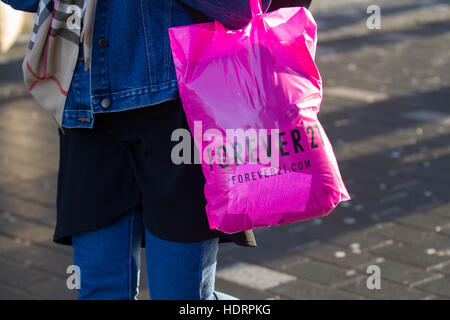 Conservare per sempre ventuno 21 store, agli acquirenti con rosa che porta regali di Natale sacchetti riutilizzabili di acquisti in Liverpool One e due, City center high street, Merseyside, Regno Unito Foto Stock