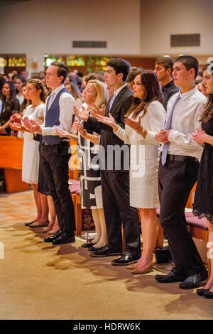Formalmente vestiti teens partecipare in massa di conferma ad una Laguna Niguel, CA, chiesa cattolica. Nota vestiti bianchi. Foto Stock
