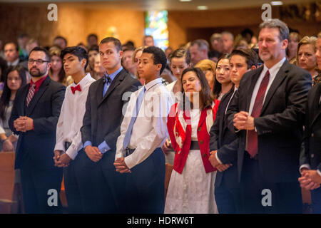 Formalmente vestiti multirazziale adolescenti e genitori di partecipare in massa di conferma ad una Laguna Niguel, CA, chiesa cattolica. Foto Stock