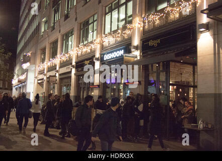 La gente in coda di notte fuori del ristorante in London West end di notte - Dishoom, St Martins Lane WC2 Foto Stock