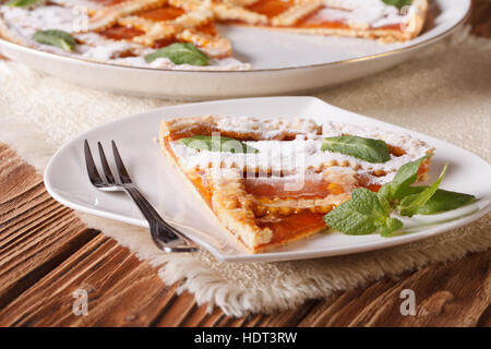 Fetta di torta italiana con marmellata di albicocche sulla tavola di close-up orizzontale. Foto Stock