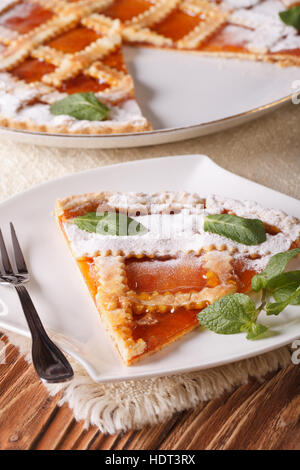 Fetta di torta italiana con marmellata di albicocche sulla tavola di close-up. In verticale Foto Stock