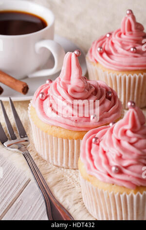 Vacanza Deliziose tortine con crema rosa e caffè vicino sul piano verticale. Foto Stock