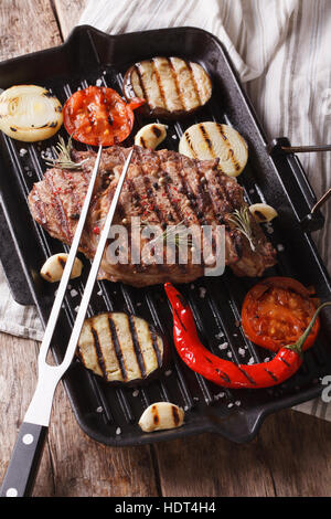 Gustose grigliate di carne di manzo e cipolle, melanzana, peperoncino in padella per grigliare closeup verticale. Foto Stock