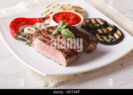 Bistecca di manzo, verdure grigliate e salsa su una piastra di close-up orizzontale. Foto Stock